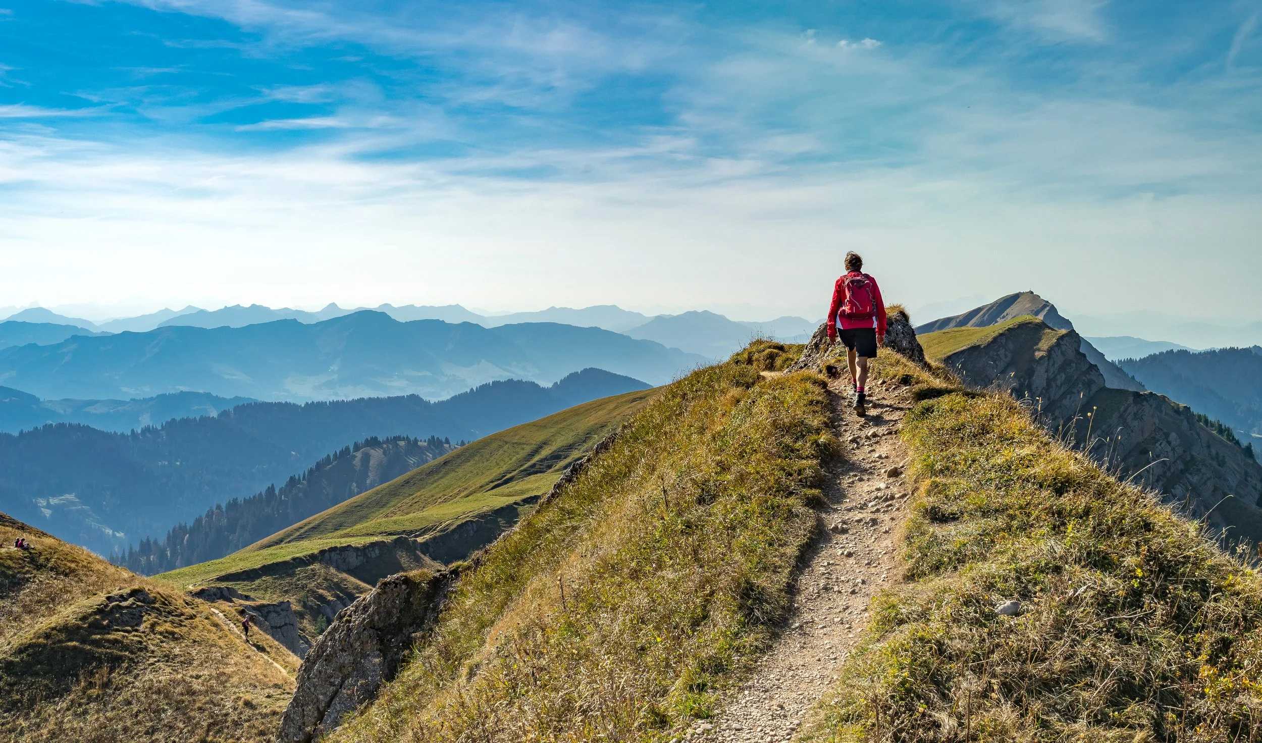 Person hiking a mountain path — representing the journey back to wellness